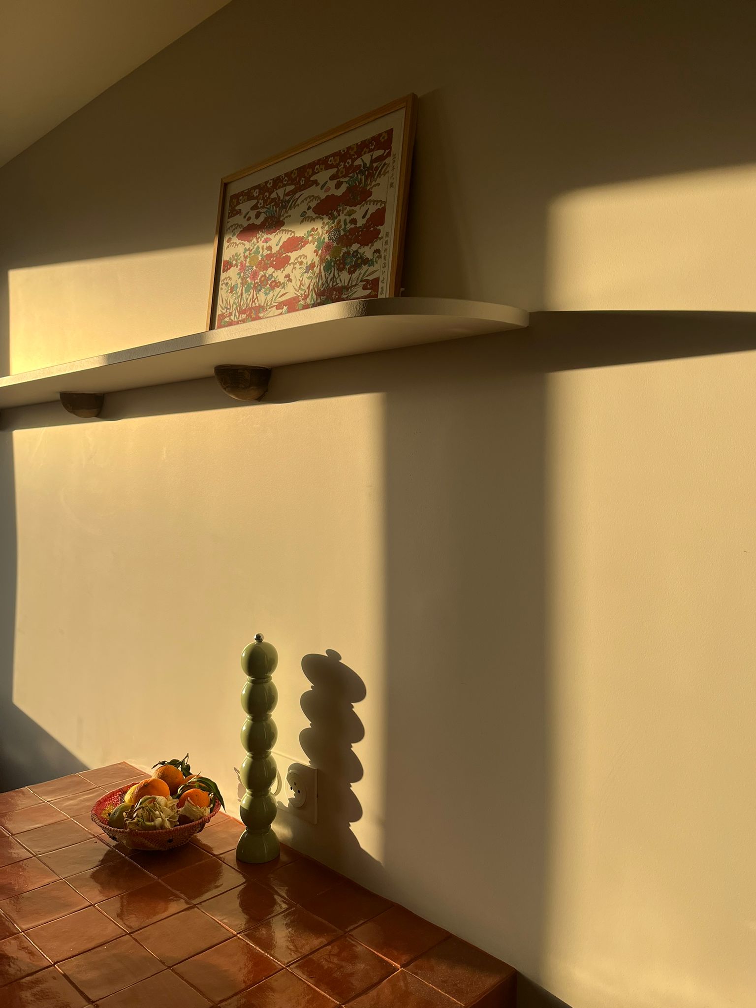 lumière du soir dans cuisine avec ilot carrelé et étagères sur mesure